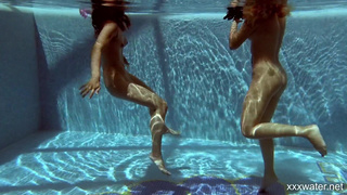 Две страстные нимфы купаются голышом в закрытом бассейне